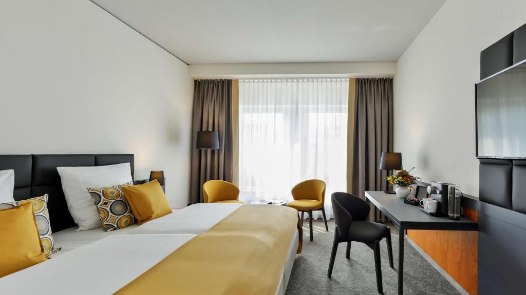 德累斯顿德累斯顿杜瑞特酒店的酒店客房设有一张大床和一张书桌。