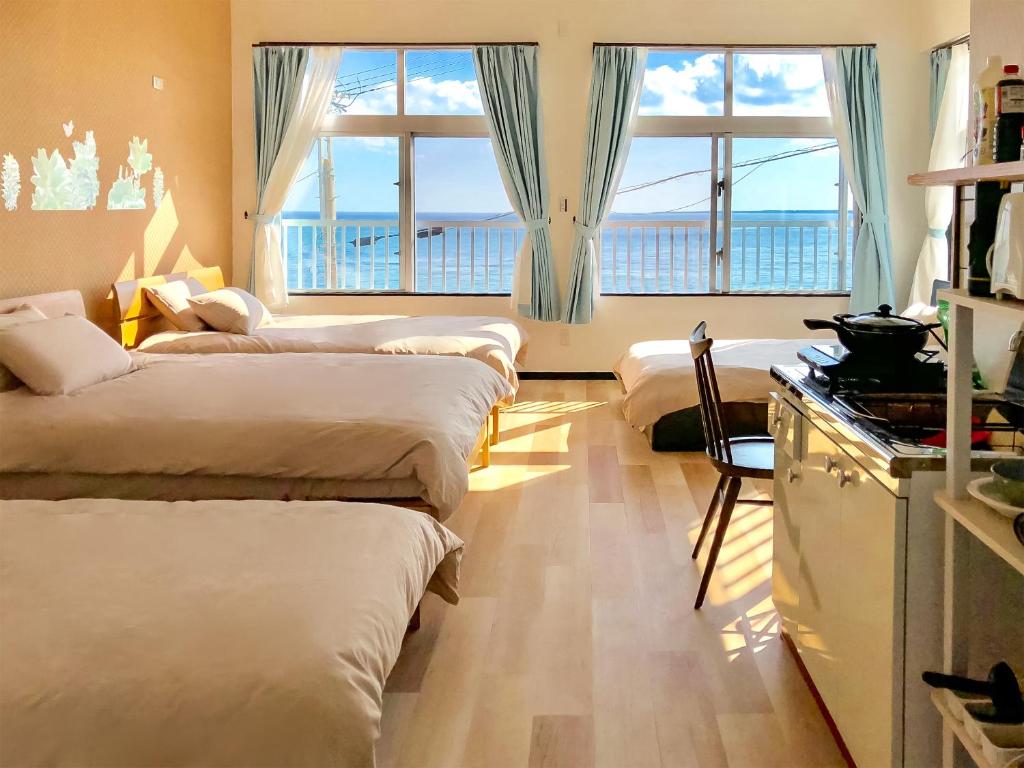 AzamaAzama Ocean View Terrace的带四张床的客房和一间带窗户的厨房