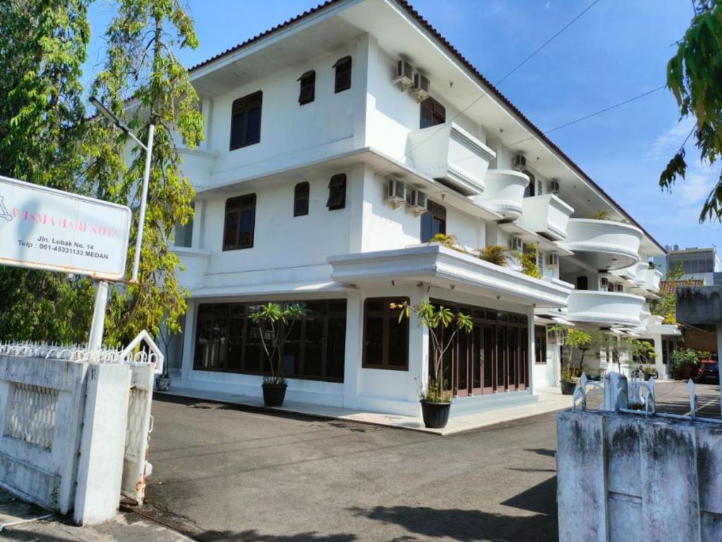 棉兰Wisma Hari Kota的前面有标志的白色建筑