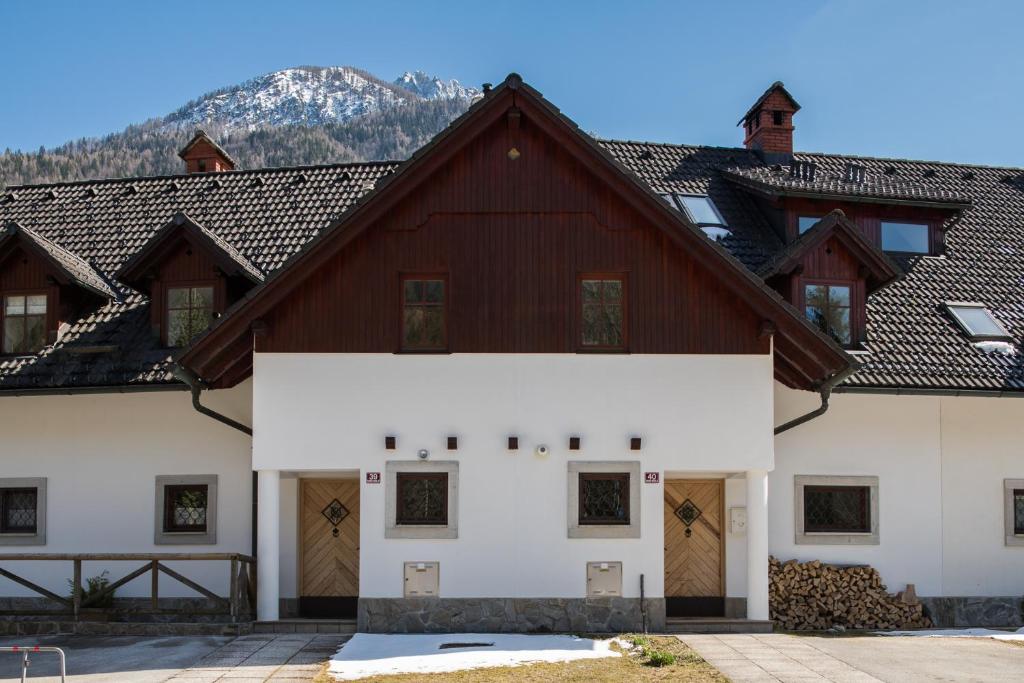 克拉尼斯卡戈拉Our Second Home in Kranjska Gora的一座白色的大建筑,有棕色的屋顶