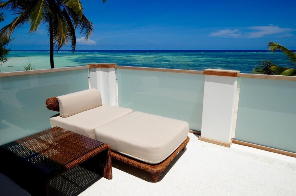 吉汶瓦Imani Penthouse - Private Beachfront apartment with Spectacular Ocean Views的海景阳台上的白色椅子和桌子