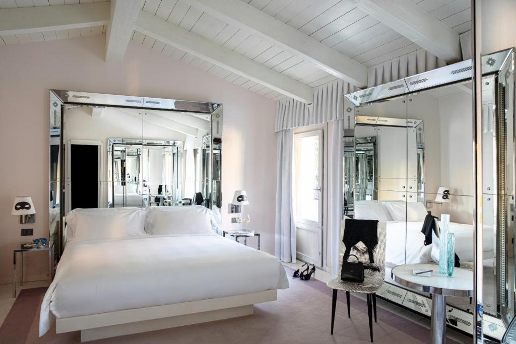 威尼斯Palazzina Grassi的卧室配有一张白色大床和镜子