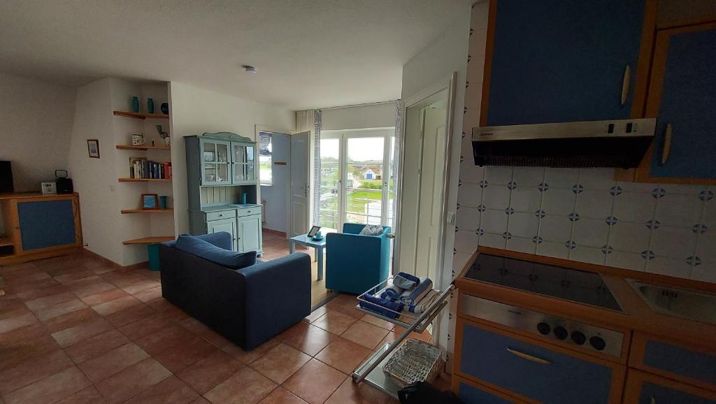 奥特里德维茨Ferienwohnung Drachen的一间带蓝色沙发的客厅和一间厨房