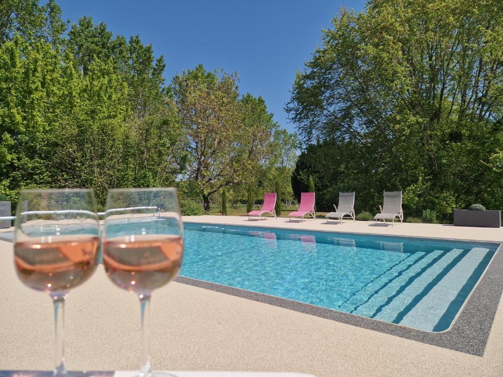 La Membrolle-sur-ChoisilleMaison/gîte-6 km de Tours的两杯葡萄酒坐在游泳池旁