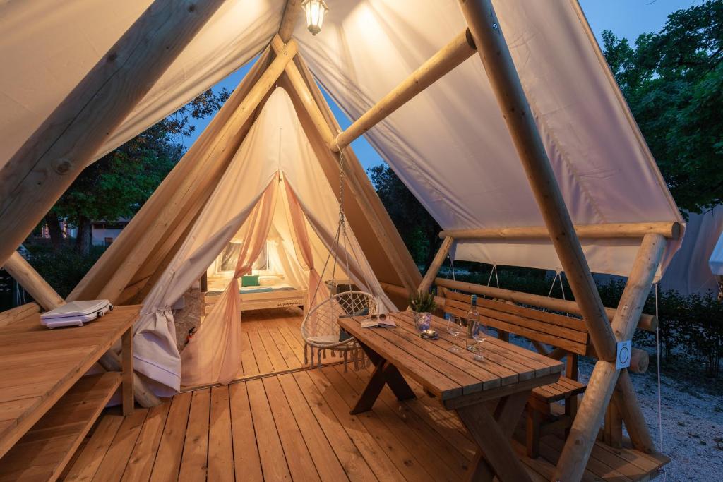 波雷奇Eco glamping- FKK Nudist Camping Solaris的帐篷设有带木桌和长凳的木甲板