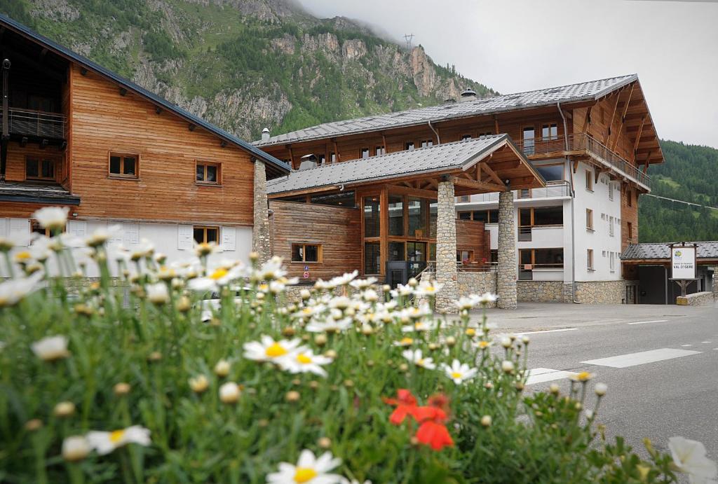 瓦勒迪泽尔Village vacances de Val d'Isère的前面有一堆鲜花的建筑
