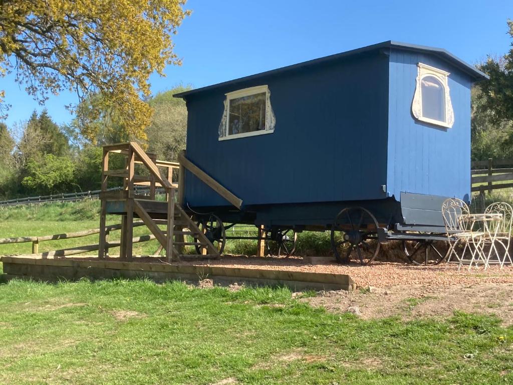 LonghopeOriginal Roadsmans Wagon with breathtaking views的坐在木板上的蓝色小房子