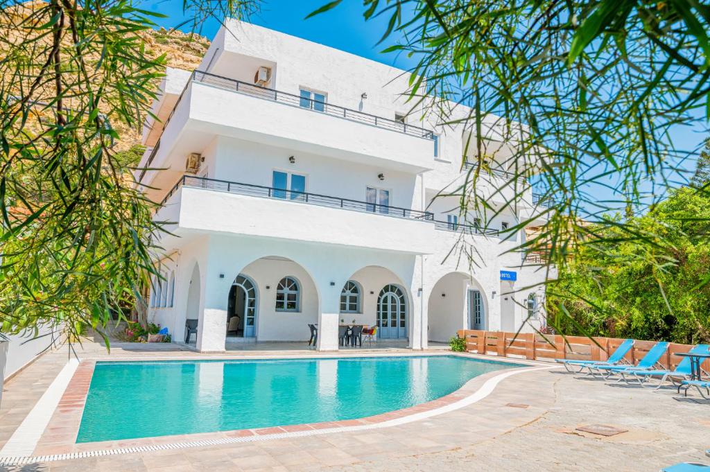 马塔拉Matala Hostel的一座别墅,在一座建筑前设有一个游泳池