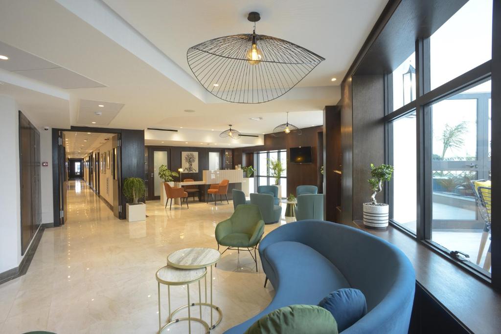 突尼斯MAIA HOTEL SUITES的大堂设有蓝色的沙发和桌椅
