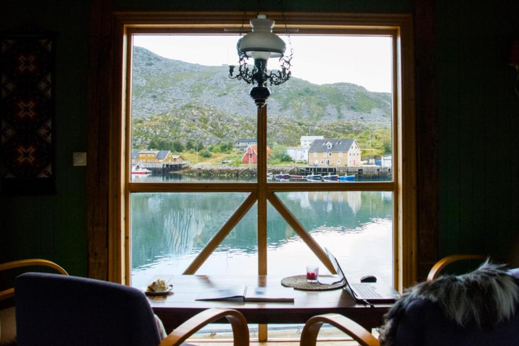 SkrovaHeimbrygga Restaurant & Accommodation的湖景窗户,配有桌子