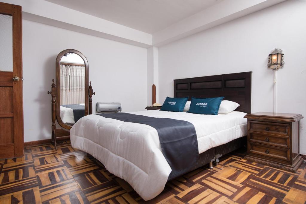 库斯科Ayenda Casa Escondida San Cristóbal Premium的一间卧室配有一张大床和镜子
