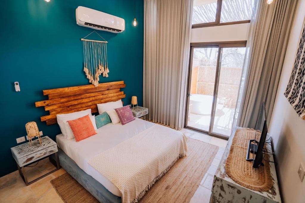 米茨佩·拉蒙Selina Desert Garden Ramon的一间卧室设有一张床和蓝色的墙壁