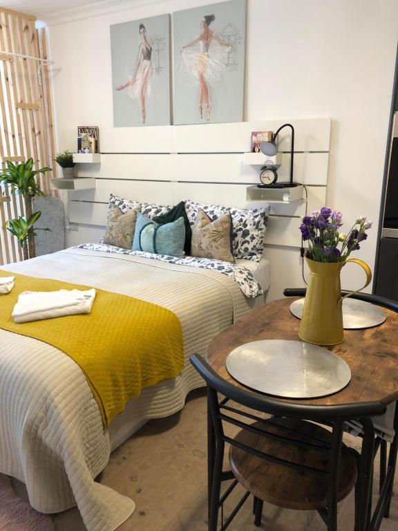 威森肖Studio Flat的一间卧室配有一张床和一张黄毯桌子