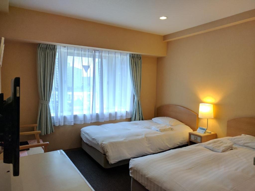 横须贺市Hotel Harbour Yokosuka - Vacation STAY 83183v的酒店客房设有两张床和窗户。