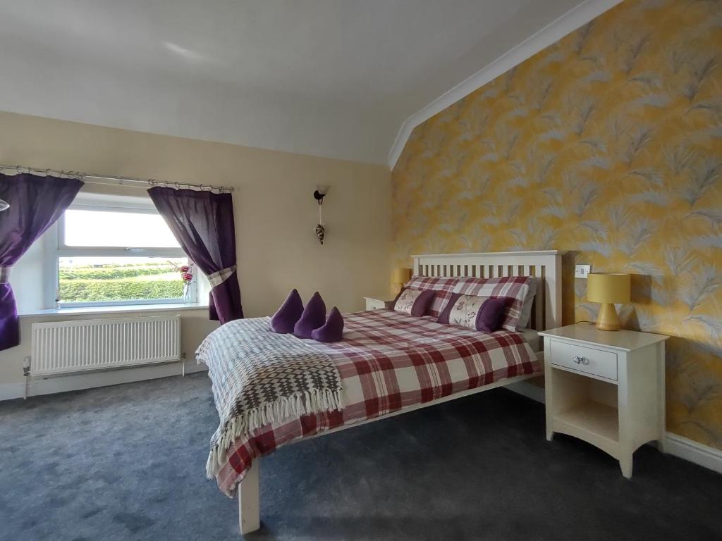 海茨托特The Shoulder at Hardstoft的一间卧室配有一张带紫色枕头的床