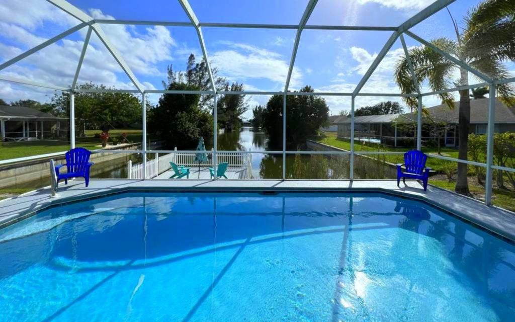 珊瑚角!NEW! Villa Sunshine private Pool的一个带蓝色椅子的大型游泳池,享有美景