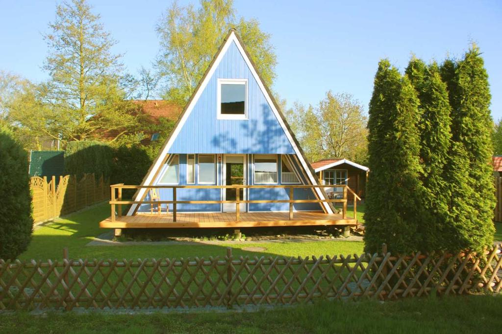 DeternFerienhaus Lüttje Swaan的院子中带蓝色屋顶的小房子