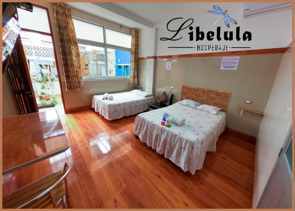 马尔多纳多港Libélula Hospedaje的铺有木地板的客房内的两张床
