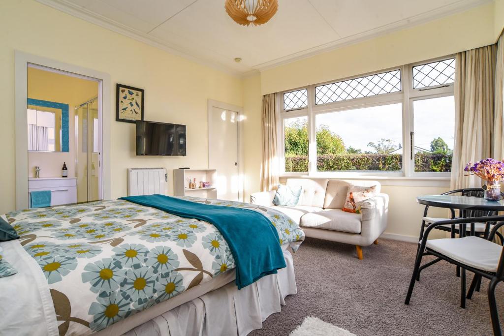 但尼丁Sunny Mornington 2 Bedroom Guest Suite的一间卧室配有一张床和一张沙发