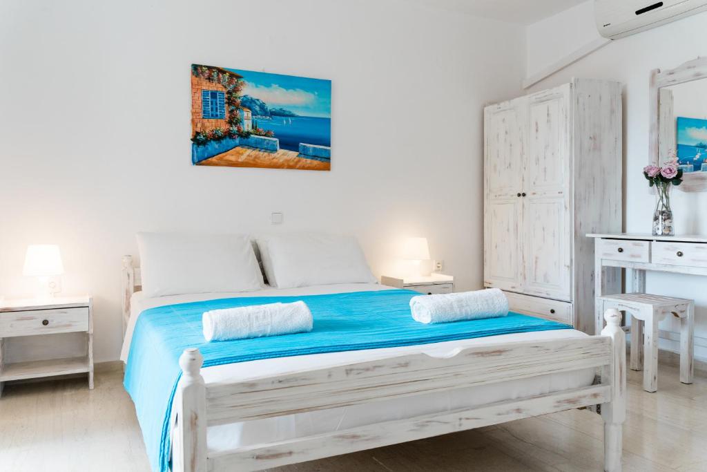 帕尔加Villa Kallithea的一间白色卧室,配有一张床和两张桌子