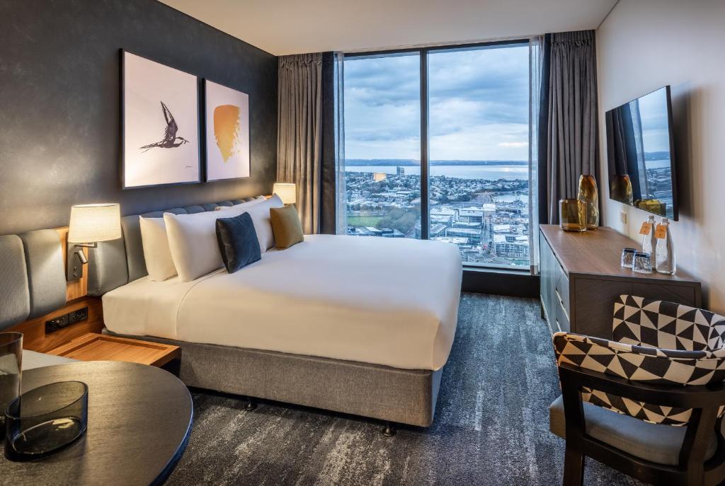 奥克兰voco Auckland City Centre, an IHG Hotel的酒店客房设有一张床和一个大窗户