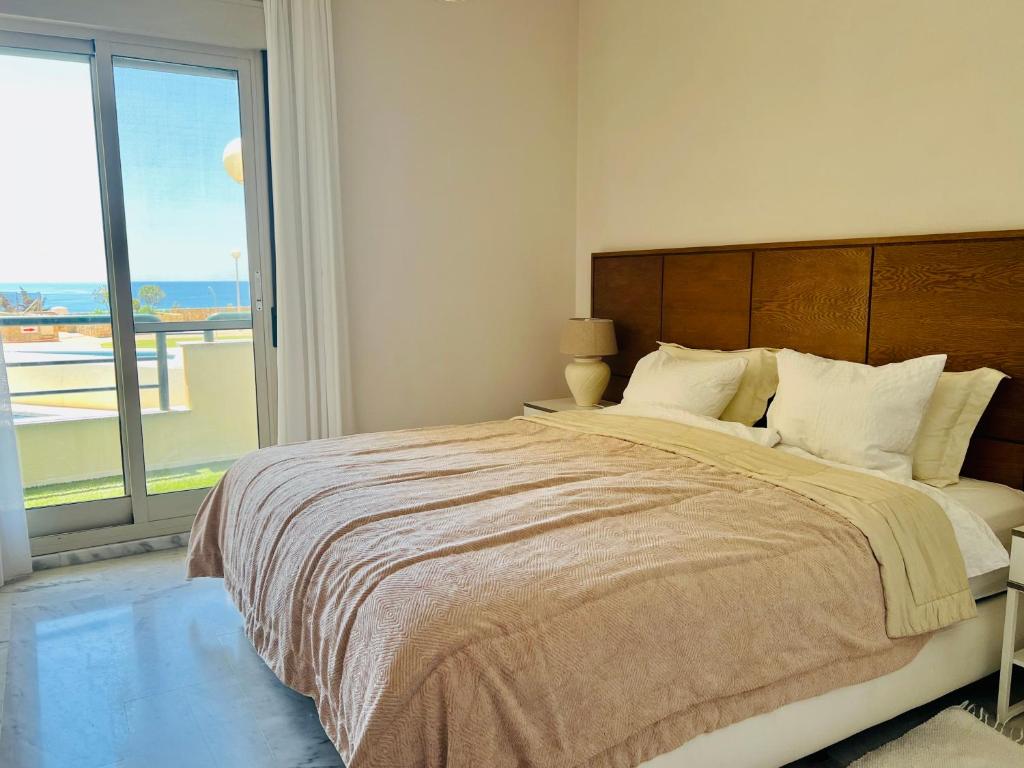 贝纳尔马德纳Apartment Sea Breeze – Apartamento Brisas del Mar的一间卧室设有一张大床和大窗户