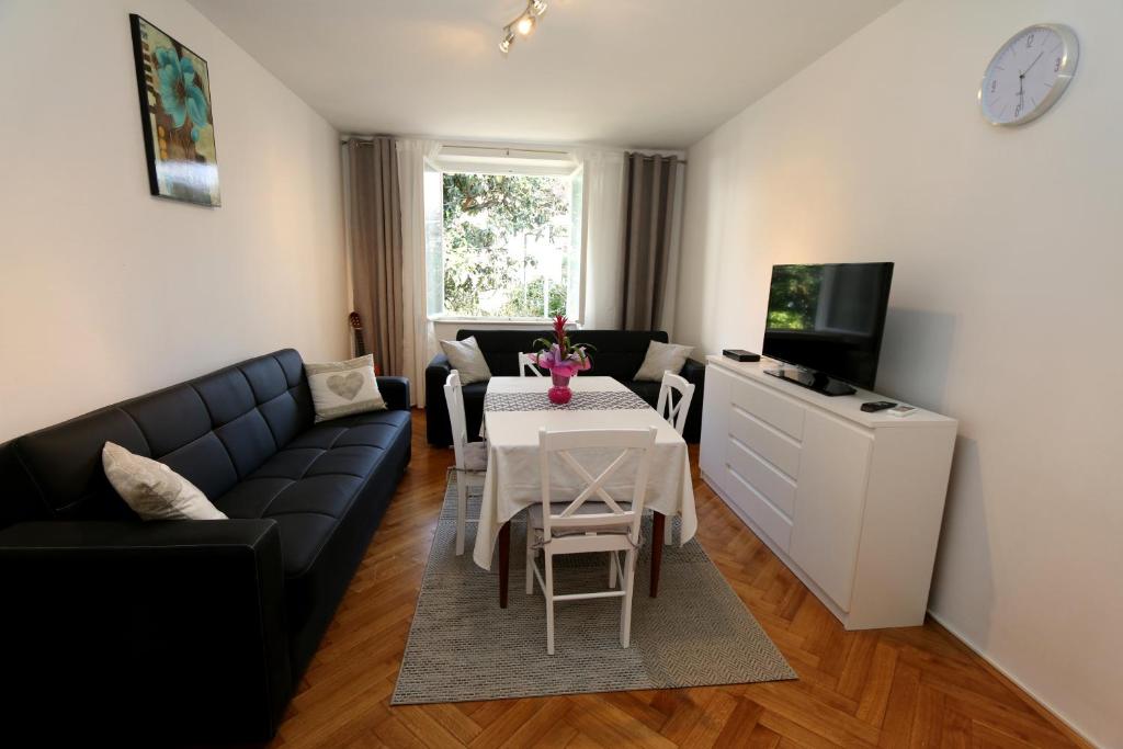 杜布罗夫尼克Apartment Mira Lapad的客厅配有黑色沙发和桌子
