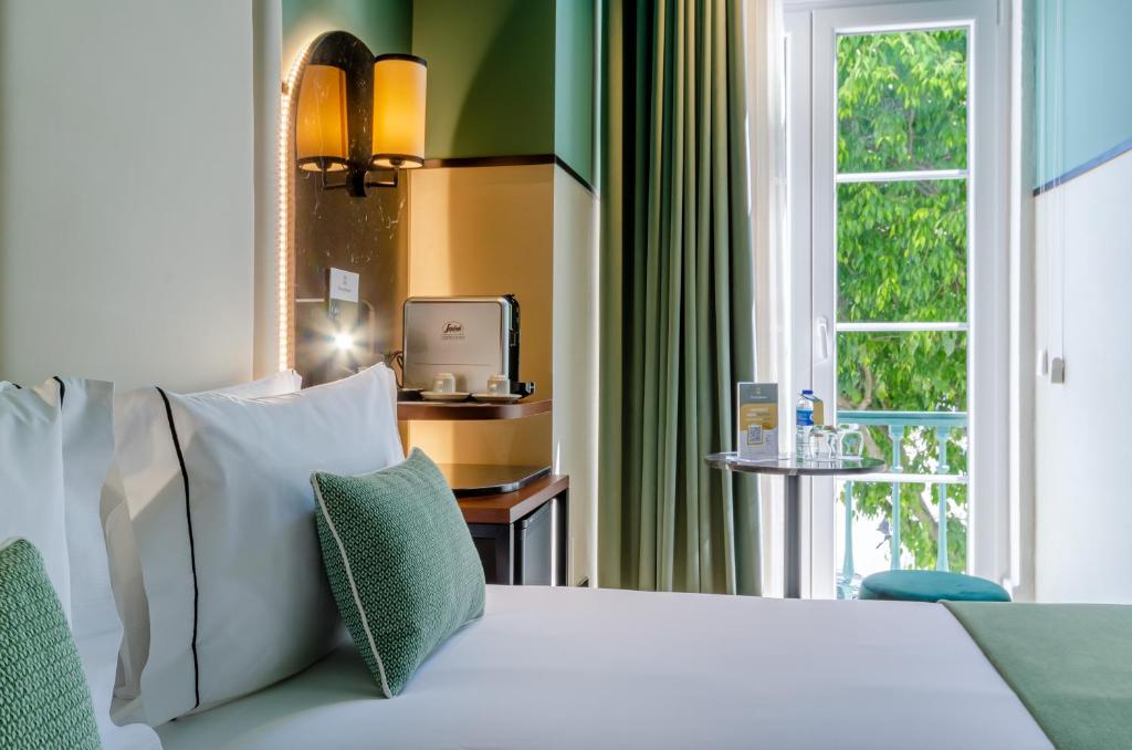里斯本Nicola Rossio Hotel的卧室配有白色的床和窗户