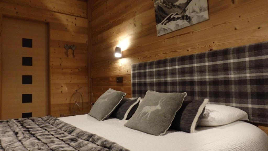 阿雷什维勒特酒店的一间带两张床铺的卧室,位于带木墙的房间内