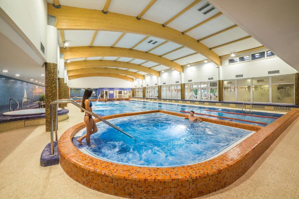 布拉格健康步骤酒店的一座大型游泳池,其中有2人