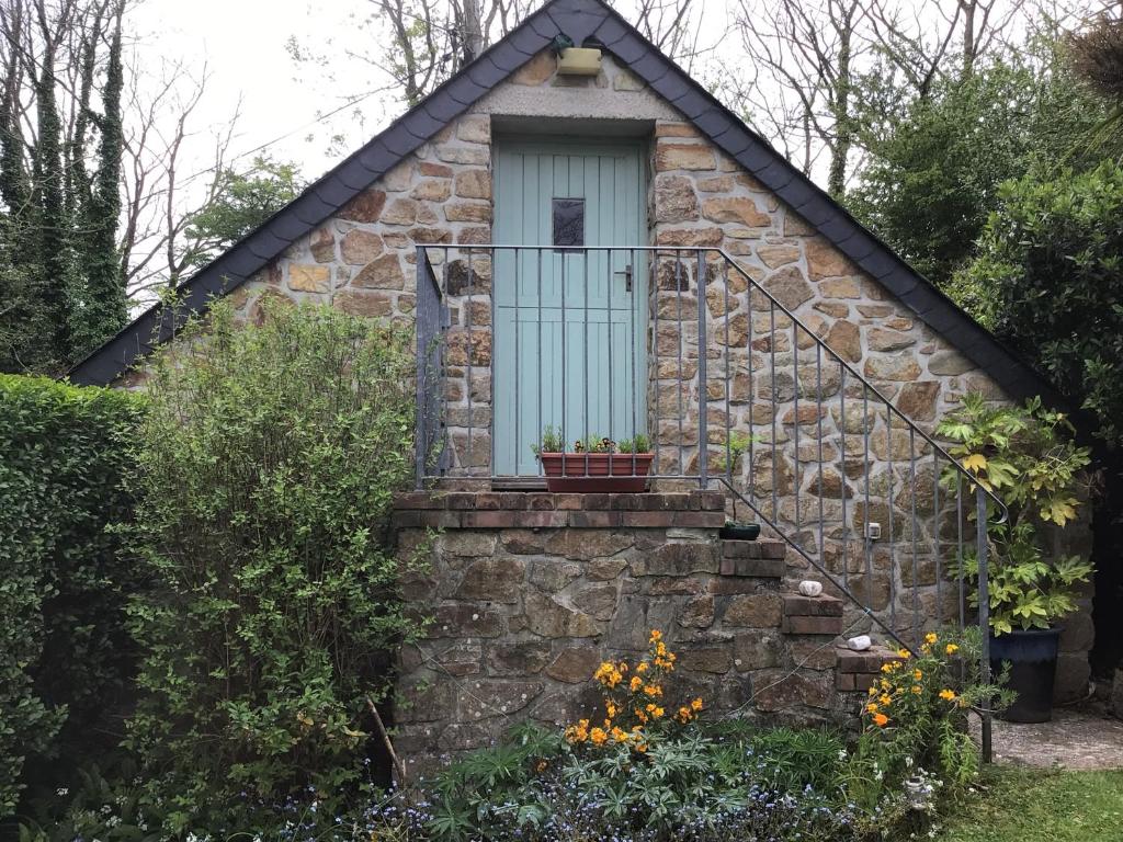 坎伯恩Charming 2-Bed Studio in Camborne的蓝色门和楼梯的小石头房子