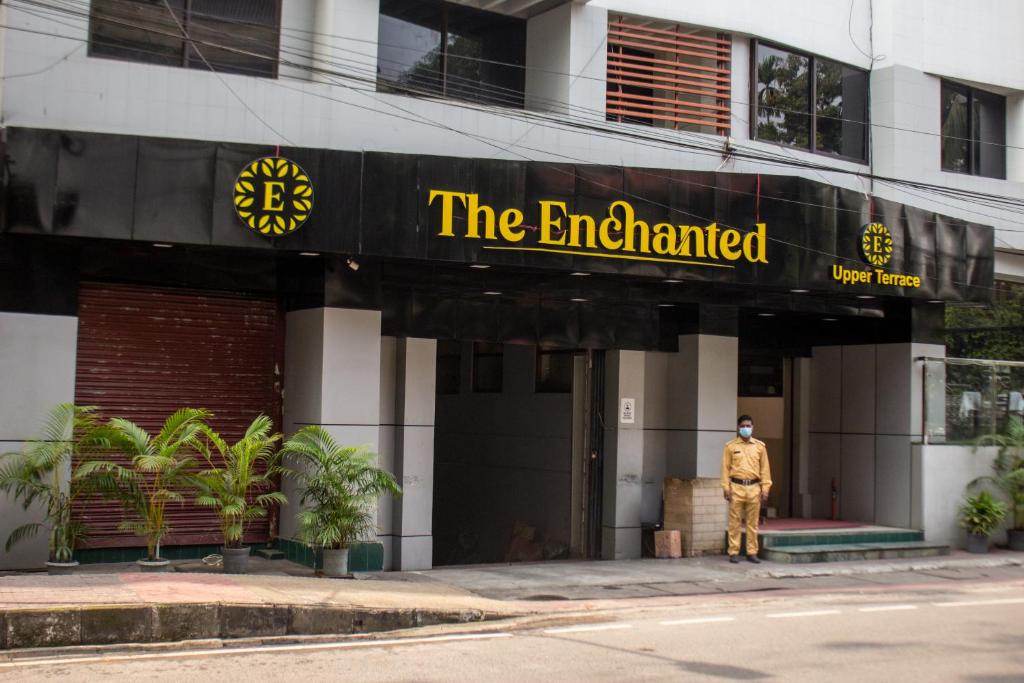 达卡Hotel The Enchanted的站在建筑物前的人