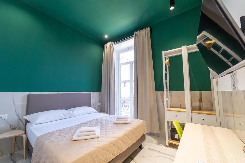 那不勒斯P.C. Boutique Medina H. Napoli Centro, by Clapa Group的一间卧室设有绿色的墙壁和一张床