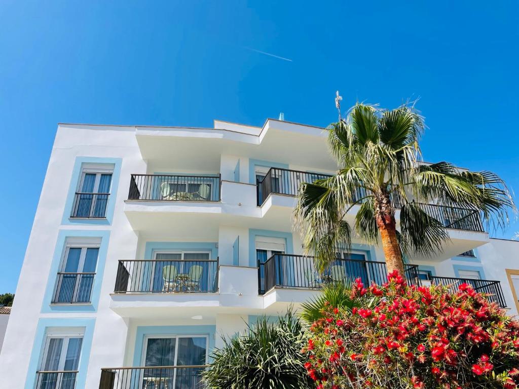 塞萨利内斯Blue House Mallorca的一座白色的建筑,前面有棕榈树