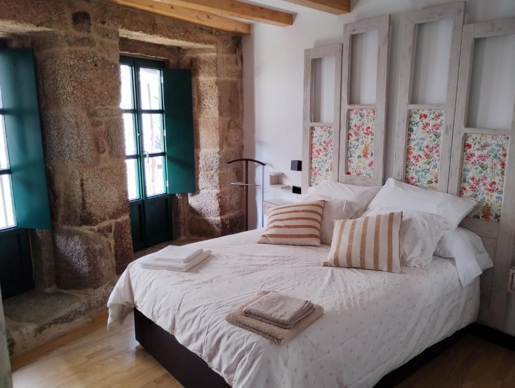 里瓦达维亚Casiña da Madalena的卧室配有一张带两个枕头的大白色床