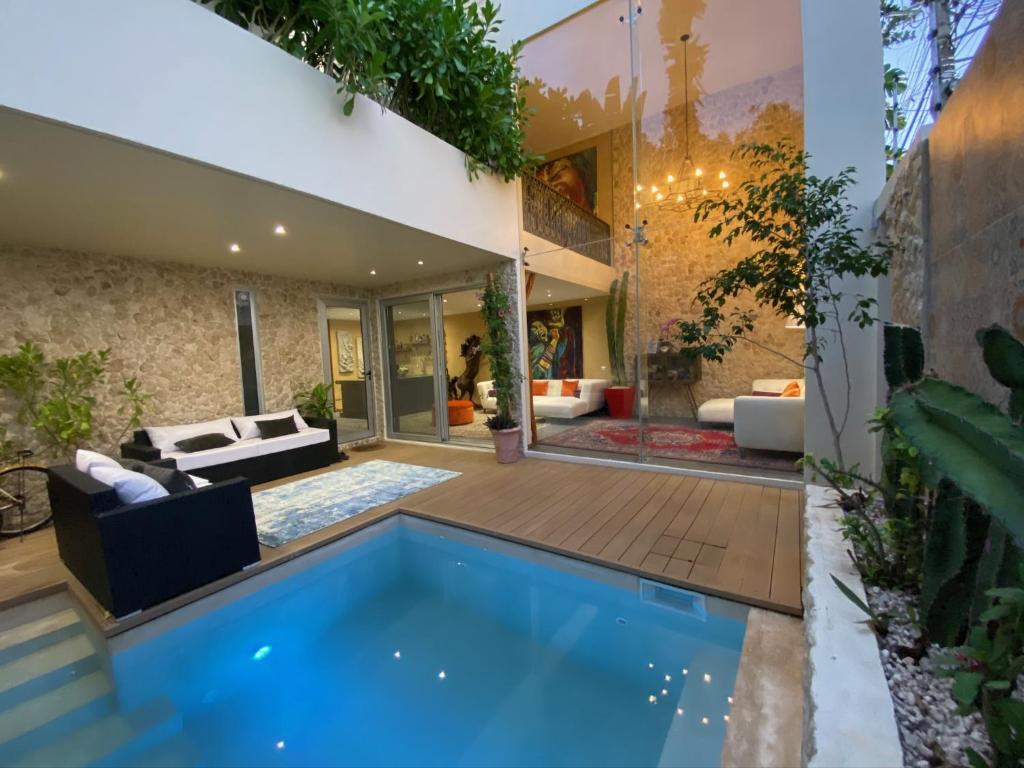 普拉亚卡门Casarte Boutique Hotel的庭院里一座蓝色泳池的房子