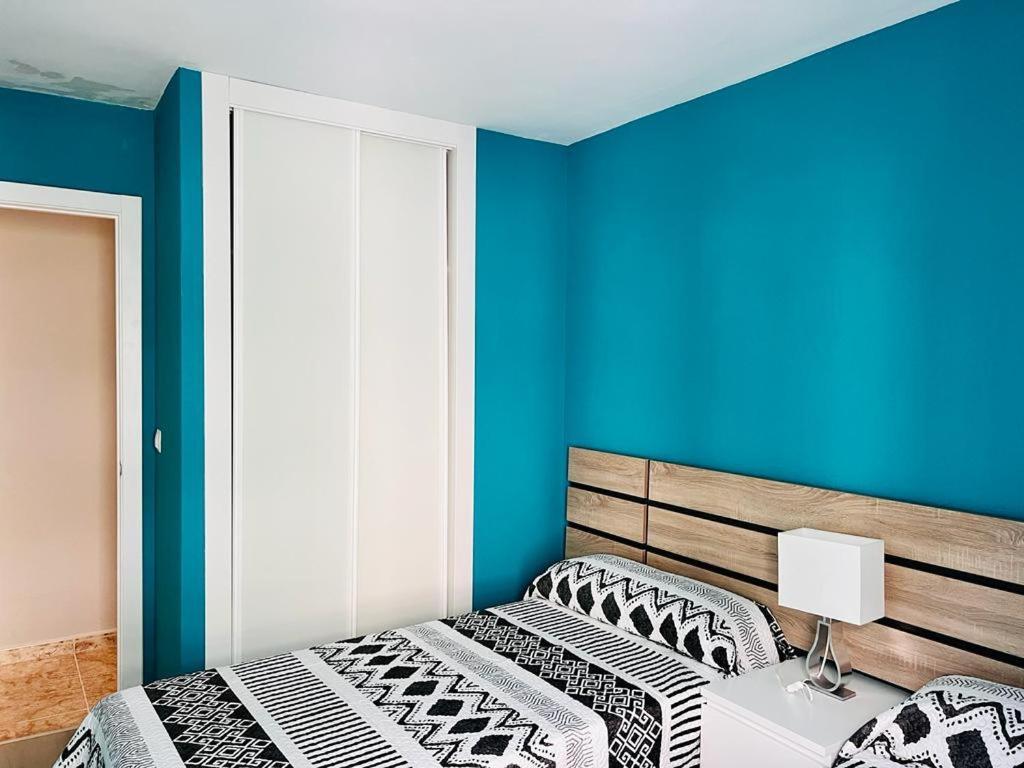 比韦罗Viveiro-Lugomar的一间卧室设有两张床和蓝色的墙壁