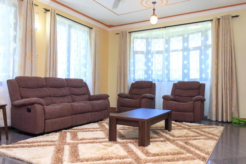 蒙巴萨SERENE 4 BEDROOMED HOME IDEAL FOR FAMILY HOLIDAY的客厅配有沙发、两把椅子和一张桌子