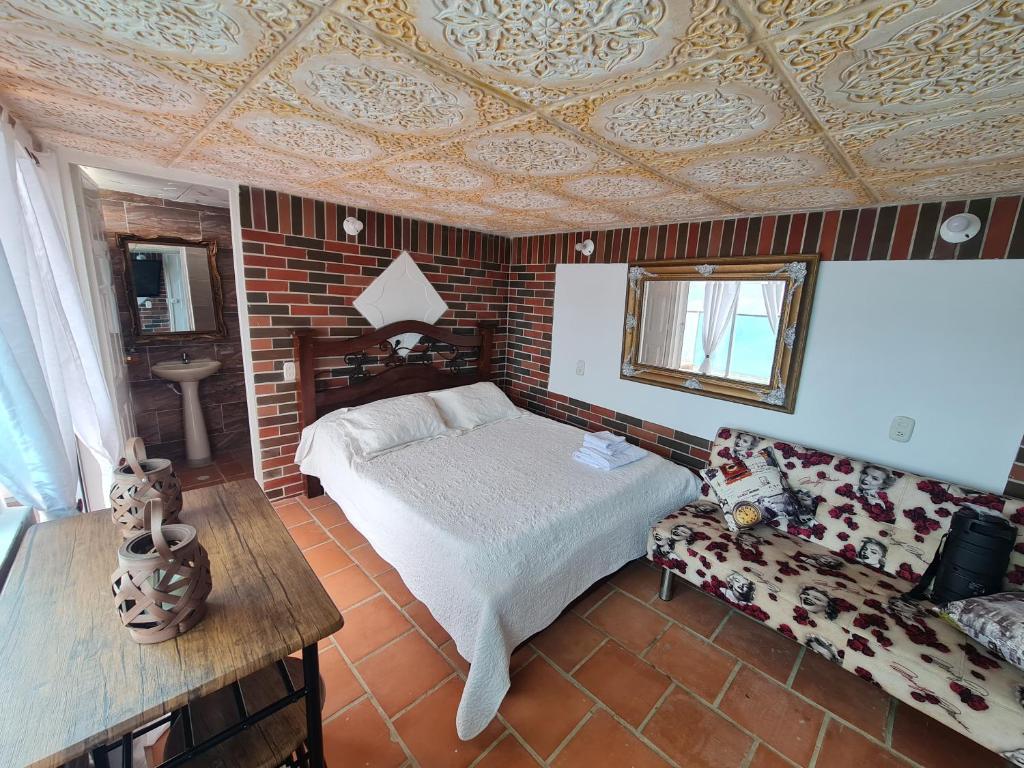 洛斯桑托斯Parque Mirador del Chicamocha的一间卧室配有一张床和一张沙发