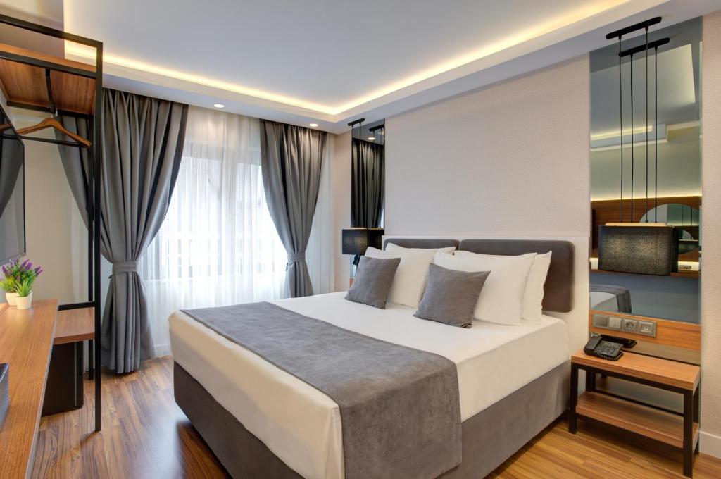 伊斯坦布尔Depiero Hotel Karaköy的一间卧室配有一张大床和一张书桌