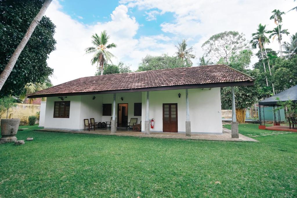 卡卢特勒Gedara Villa的一座带草地庭院的白色小房子