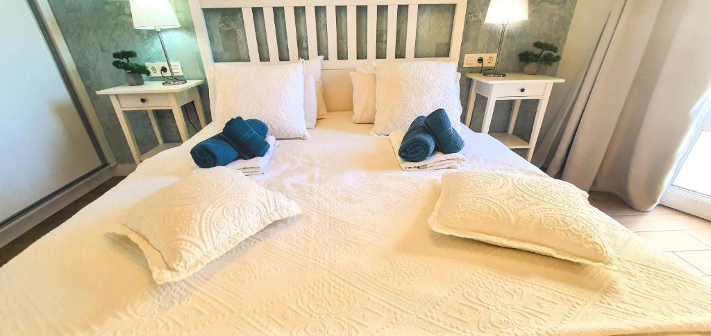阿罗纳Harmony Apartments的一张带两个蓝色枕头的大白色床