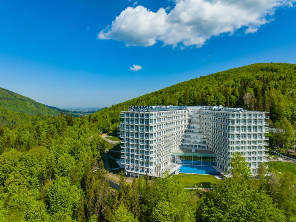 维斯瓦Crystal Mountain Hotel Wisła的森林中间的白色大建筑