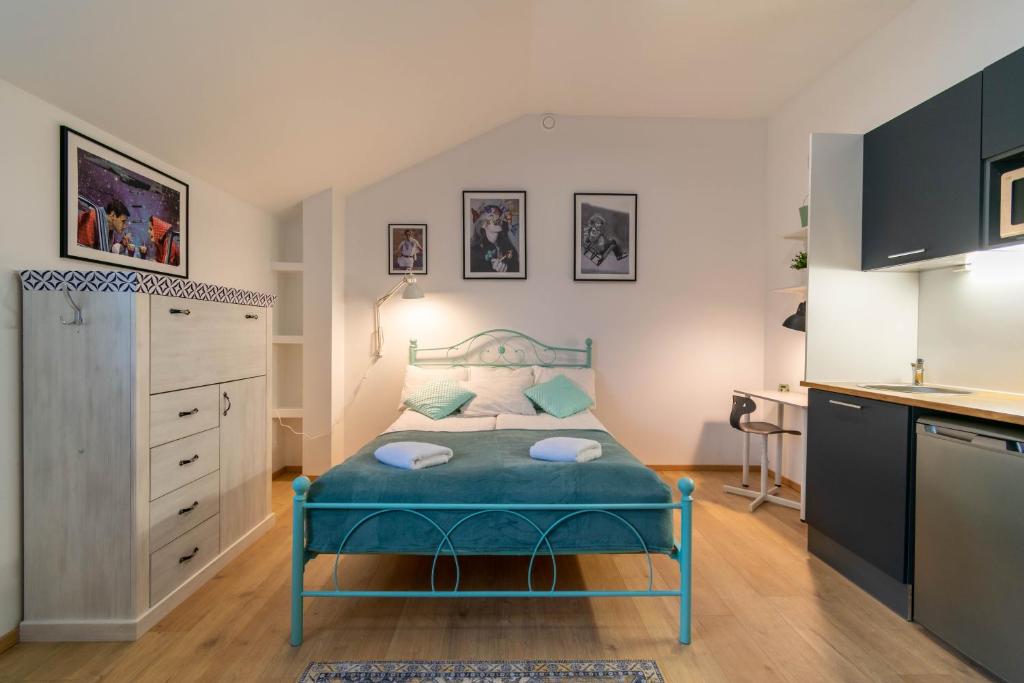 拉克韦雷Apartments24 Spordi的一间设有蓝色床和厨房的小卧室