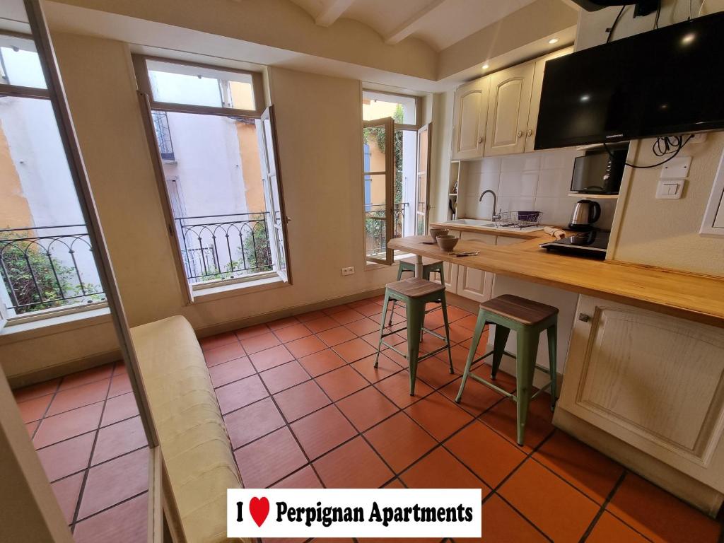 佩皮尼昂I Love Perpignan Apartments 8的厨房配有白色橱柜和红色瓷砖地板。