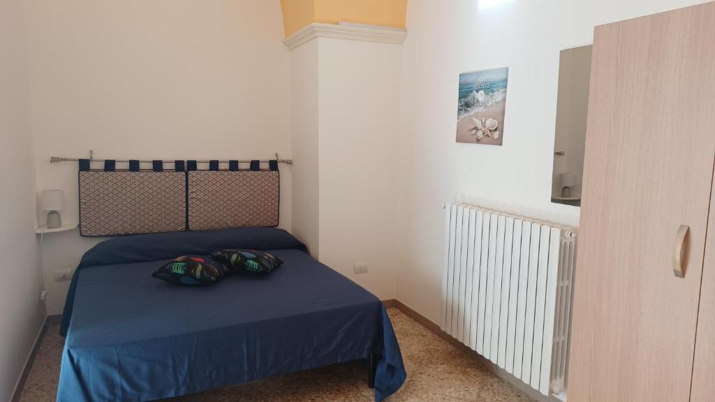 科佩尔蒂诺STANZA UNO G. G CONTE的一间卧室配有一张带蓝色床罩和两把头盔的床。
