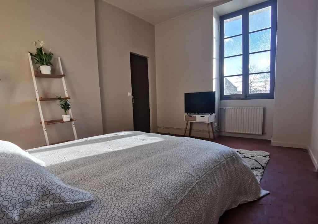 丰特奈·特雷西尼Domaine de la Ferme de Jean Grogne的一间卧室配有一张大床和电视