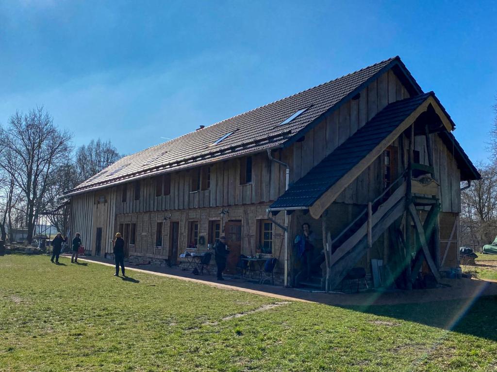 布尔格Scheunenherberge Schäfchenzählerei的一座大型木制谷仓,外面的人站在谷仓外面