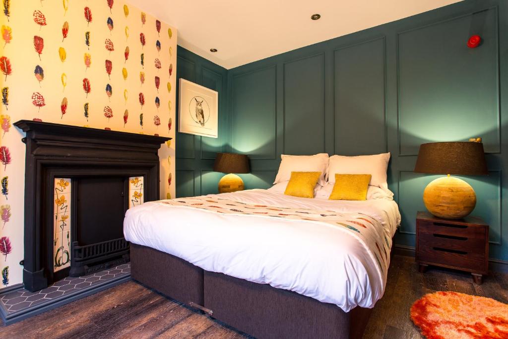 贝里Eagle and Child, Ramsbottom的一间卧室设有一张带绿色墙壁的床和壁炉
