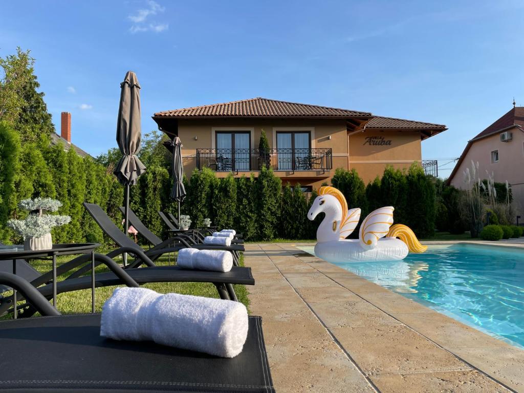 凯斯特海伊Villa Aruba & Private SPA Suites的后院设有游泳池、椅子和房屋